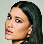 Close-up portrait of Julia Jones with sleek, side-parted black hair, softly smoky eye makeup and muted pink lipstick.