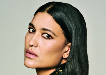 Close-up portrait of Julia Jones with sleek, side-parted black hair, softly smoky eye makeup and muted pink lipstick.